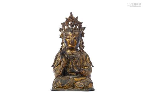 A CHINESE GILT BRONZE FIGURE OF GUANYIN. Ming Dynasty. Seated in long flowing robes, a serene