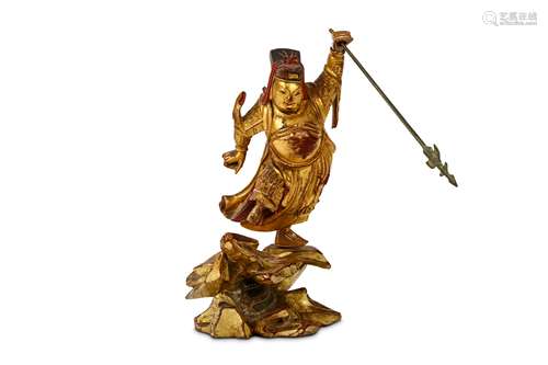 A CHINESE CARVED GILT-LACQUER WOOD FIGURE. Qing Dynasty, 19th Century. Standing on one foot on a