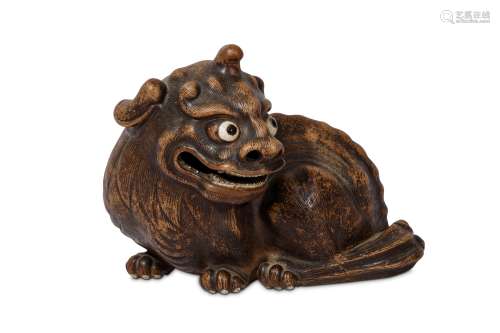 A CHINESE SLIP-DECORATED SEATED QILIN. Qing Dynasty, Jiaqing era. Seated with the legs tucked