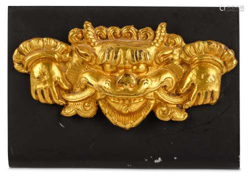 A GILT COPPER PLAQUE DEPICTING KIRTIMUKHA. Tibet, 18th / 19th Century. 8.5cm long. (2) 西藏十八 / 十九世紀