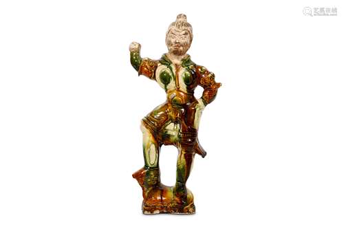 A CHINESE SANCAI-GLAZED POTTERY FIGURE OF A LOKOPALA. Tang Dynasty. Standing triumphantly on the