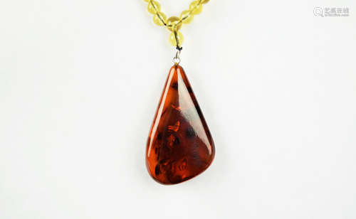 A Red Amber Pendant with Amber Bead Necklace