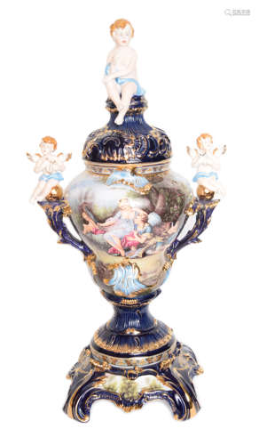 A 92cm Large Continental Indigo Ground Porcelain Lidded Urn with Three Cherubs