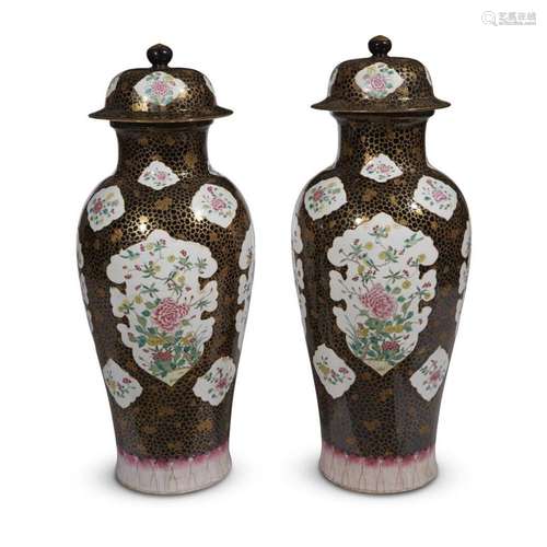 A pair of famille rose-decorated black-ground large porcelain vases and covers,