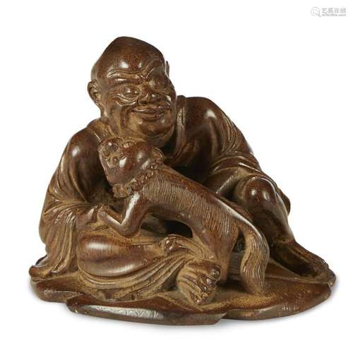 A Chinese carved bamboo figure of a seated Lohan and lion, qing dynasty