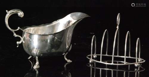 A hallmarked silver sauce boat raised on three stepped feet and terminating in acanthus capped flying scroll handle