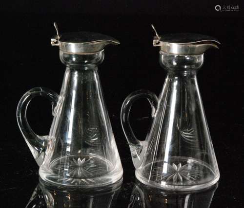 A pair of hallmarked and clear glass silver toddy water jugs