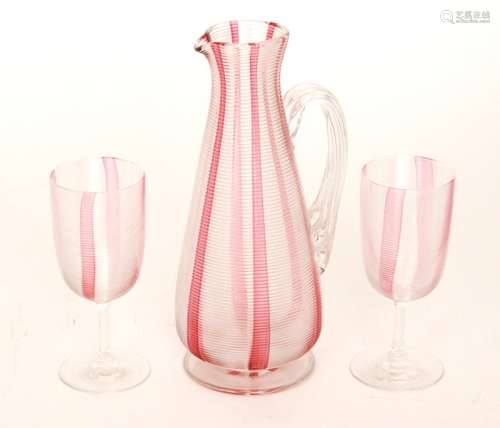 A late 19th Century Stourbridge glass water jug of footed conical form with applied fluted handle