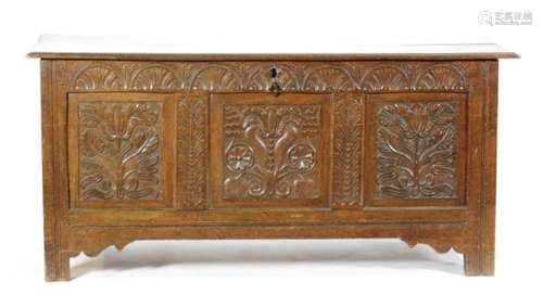 An 18th Century carved oak coffer the carved panelled front below a lunette design on stiles