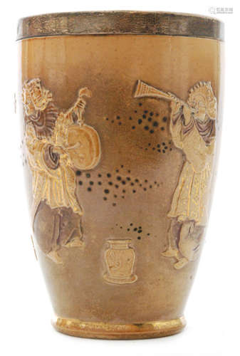 An early 20th Century Doulton Lambeth Japonesque silver collared beaker decorated with low relief scenes of Japanese musicians and a Samurai warrior with gilt burnished detailing