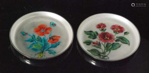 A pair of Danish sterling silver circular pin dishes each with enamel floral spray decoration to a pale grey ground