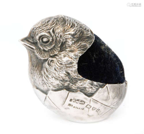 An Edwardian hallmarked silver pin cushion modelled as a hatching chick with blue velvet cushion