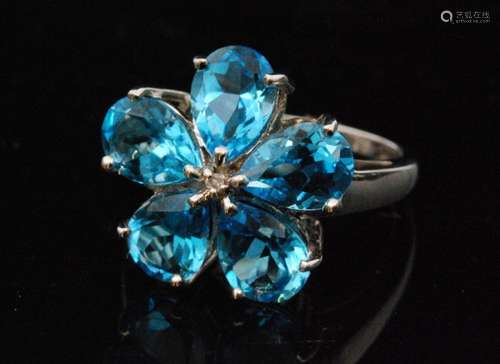 A modern 9ct white gold blue topaz and diamond cluster ring modelled as a flower head with five pearl cut topaz radiating from a central diamond