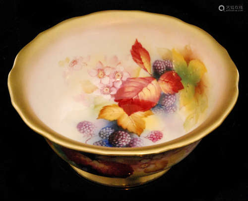 A Royal Worcester footed bowl decorated by Kitty Blake with hand painted autumnal fruits and foliage against a pale ground