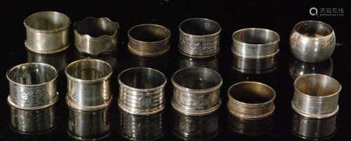 Twelve assorted hallmarked silver circular napkin rings to include engine turned and foliate engraved examples