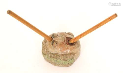 A small early 20th Century salt glazed pen stand modelled as a screaming man with a foliate garland in his hair