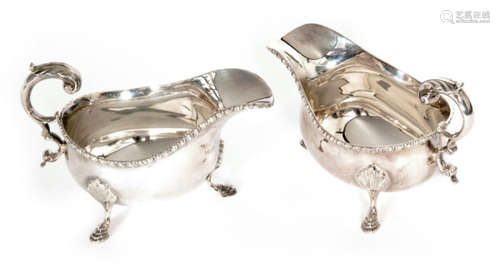 A pair of hallmarked silver sauce boats each raised on three stepped pad feet below gadroon borders and acanthus capped flying scroll handles