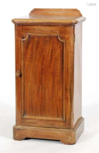 A Victorian mahogany bedside cupboard enclosed by a panel door