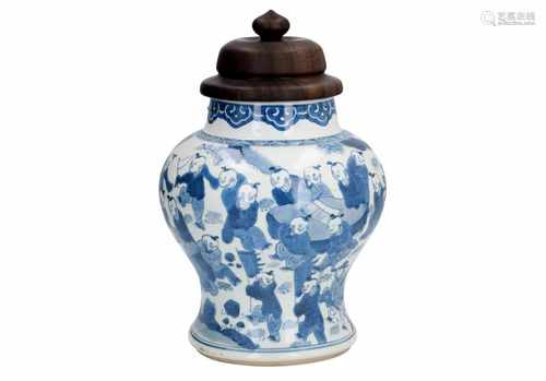 A blue and white porcelain baluster vase with wooden lid, decorated with little boys in a garden.