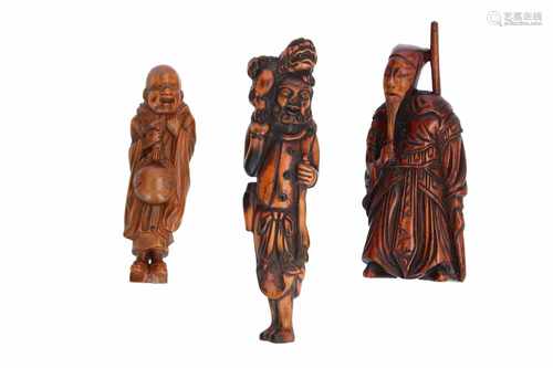 Lot of three netsuke, 1) Wooden standing monk with temple bell. H. 8 cm. 2) Wooden god of war with