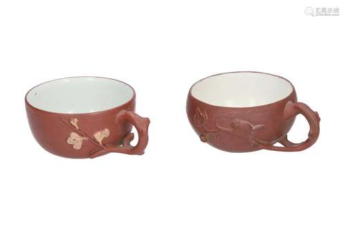 A lot of two Yixing cups, decorated with branch and animal in relief. Unmarked. China, 19th century.