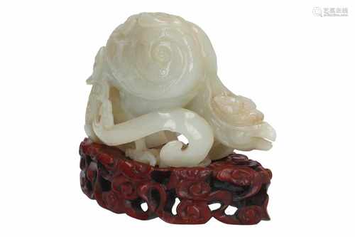 A jade sculpture on wooden base, depicting a bird of prey. China, 20th century. L. 12,5 cm. H. 8 cm.