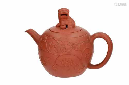 A large Yixing teapot with relief decor of flowers. The grip in the shape of a lion with moving ball