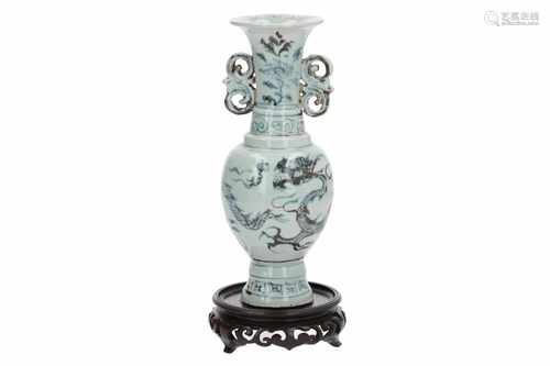 A grayisch blue and white porcelain vase with flaring rim and open work handles on wooden base,