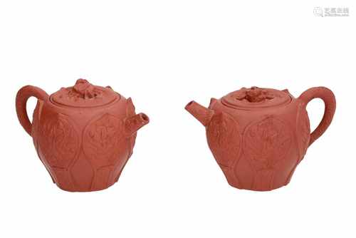 A pair of Yixing teapots with relief decor of flowers. Unmarked. China, 18th century. H. 8 cm.