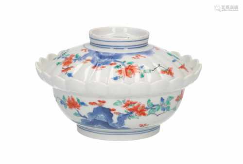 A Kakiemon lidded bowl with floral decor. The rim of the bowl and lid in chrysanthemum-shape.