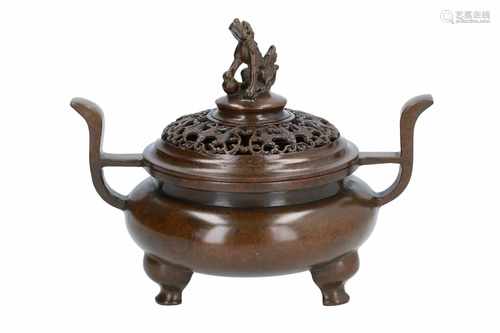 A bronze tripod censer with two handles. The cover decorated with open work and the knob in the