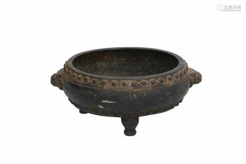 A bronze tripod censer with dots in relief and grips in the shape of animal heads. Marked with