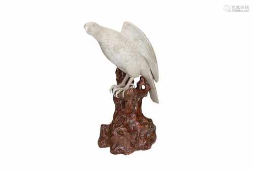 A porcelain sculpture of an eagle on a brown glazed rock. Unmarked. China, Shiwan, 20th century.