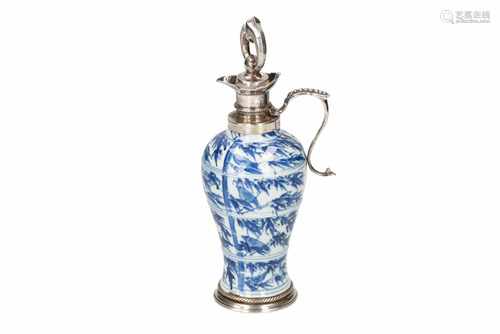 A blue and white porcelain jug, decorated with birds sitting on branches, with silver mounting.