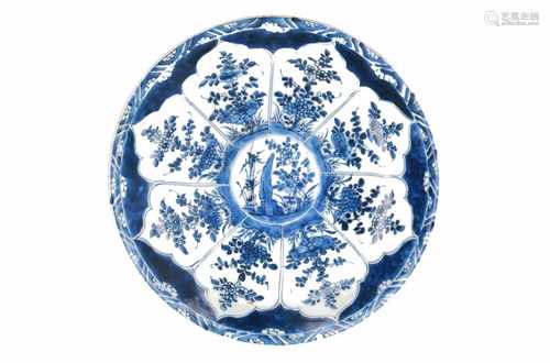 A blue and white porcelain charger with floral decor. Marked with Artemisia leaf. China, Kangxi.