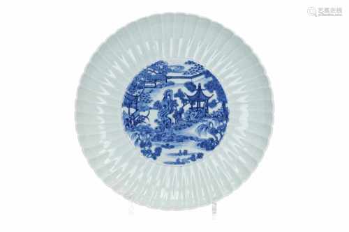 A blue and white porcelain dish with scalloped rim, decorated with a river landscape. Marked with