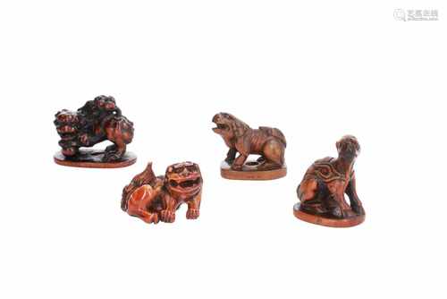 Lot of four netsuke, 1) Wooden shishi on base. Signed. H. 3 cm. 2) Wooden kirin on base. H. 4 cm. 3)