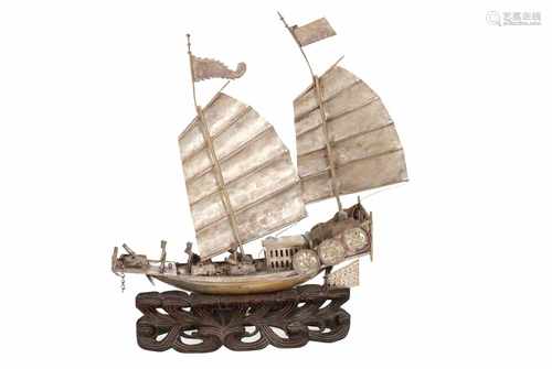 A miniature (below Dutch alloy) silver ship. China, ca.1920. On wooden base. H. 26 cm.