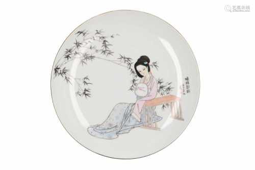 A polychrome porcelain dish, decorated with a lady, table and bamboo. Created 1990. Signed Wang