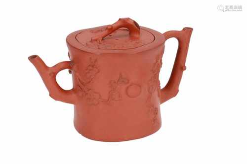 A Yixing teapot with two spouts, with relief decor of flower branches. The grip and spouts in the