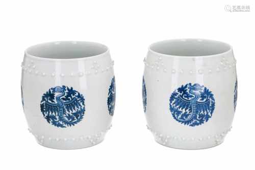 A pair of blue and white round porcelain cachepots, decoracted with phoenix and knobs in relief.