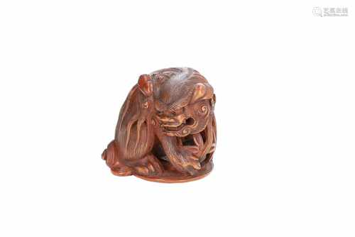 Wooden netsuke of shishi with carved loose inner ball. Signed Tomokazu. Japan, 19th century. H. 3,