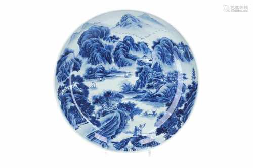 A blue and white porcelain deep charger, decorated with mountainous river landscape with boats.