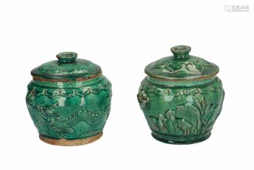 A pair of green glazed stoneware lidded jars with relief decor of dragons and animals. Unmarked.