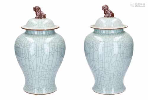 A lot of two light celadon lidded vases, knobs in the shape of a fo-dog. Marked with symbol.