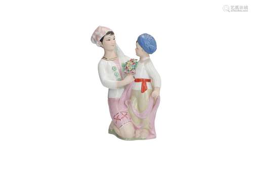 A polychrome porcelain communistic sculpture of a mother with daughter. Marked with characters.