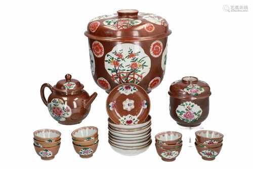 A lot of capucine porcelain items with floral decor, including two lidded jars, a teapot, 12 cups