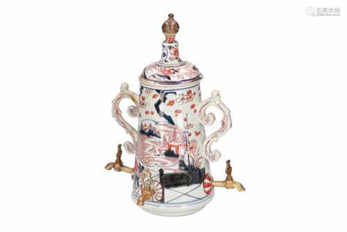 An Imari porcelain jug with three taps, decorated with flowers and buildings in a landscape.