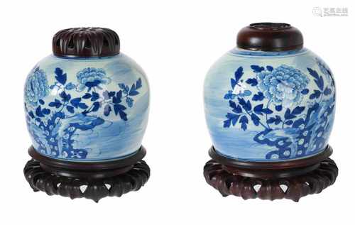 A lot of two blue and white porcelain jars with floral decor, with wooden cover and stand. Unmarked.