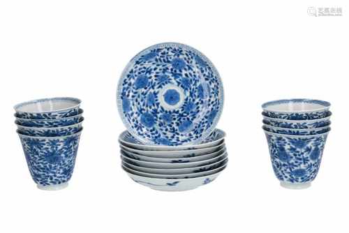 A lot of eight blue and white porcelain cups with saucers, decorated with flowers. Marked with